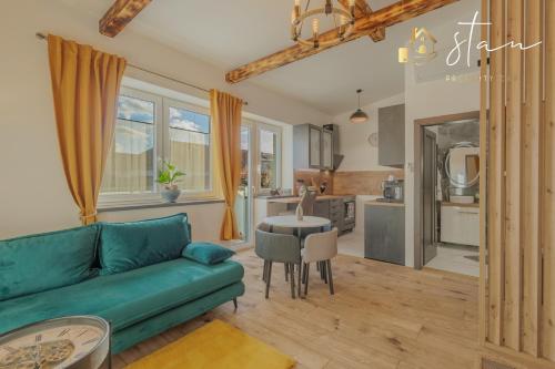 a living room with a green couch and a kitchen at Residence S7 - Luxury living Apartment in Prešov