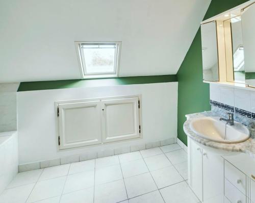 une salle de bain avec un lavabo et une fenêtre dans l'établissement La Ferme de Franqueville 'Big Gîte', à Sainte-Marie-du-Mont