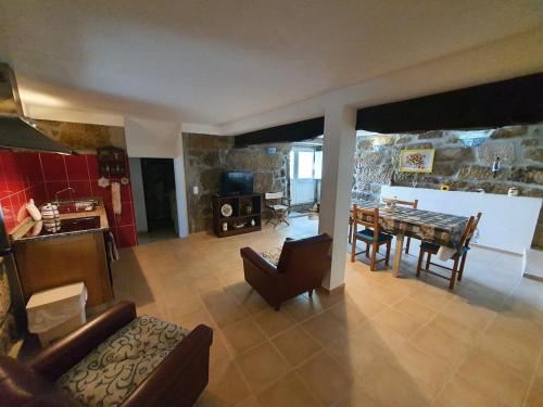 un soggiorno con un tavolo e una sala da pranzo di Casa do Tinte - Gouveia-Folgosinho a Vila Cortês da Serra