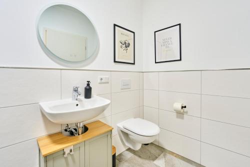 a bathroom with a sink and a toilet and a mirror at Bernstein Apartments in Pouch