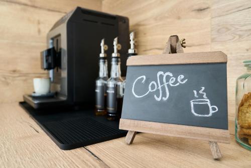 a sign with coffee written on it next to a coffee machine at Bernstein Apartments in Pouch