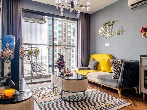 a living room with a couch and a large window at Vinhomes Ocean Park Gia Lam by QMP in Hanoi