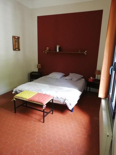 une chambre avec un lit et un banc dans l'établissement Chez Véronique et Didier, à Aimargues