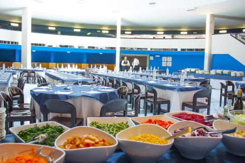 a buffet line of tables with bowls of food at Corvino Resort in Monopoli