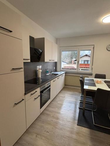 a kitchen with white cabinets and a table and a window at Attraktive Ferienwohnung in 35606 Solms, Wellness exklusiv im benachbarten Braunfels in Braunfels