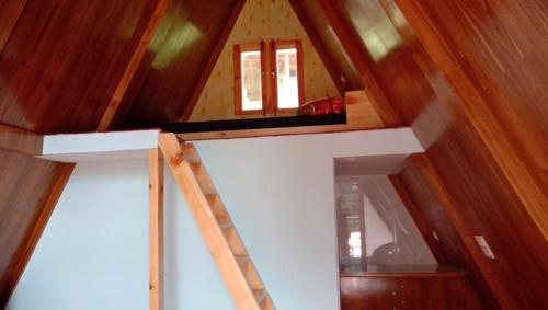 an attic room with a staircase in a house at Mahamaya camping Tosh in Tosh