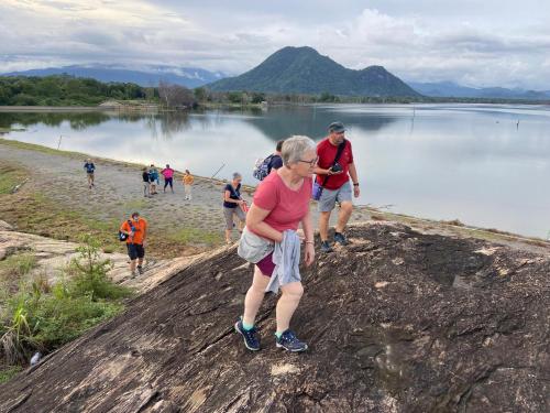 a group of people walking on the shore of a lake at Moonshade Handapanagala in Monaragala