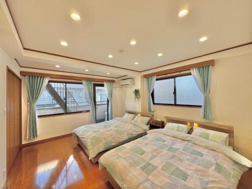 two beds in a bedroom with two windows at sun inn in Tokyo