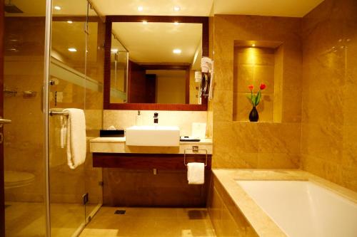 a bathroom with a sink and a bath tub at The Raviz Calicut in Kozhikode