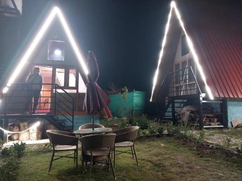 a group of chairs and a table in front of a house at Mahamaya camping Tosh in Tosh
