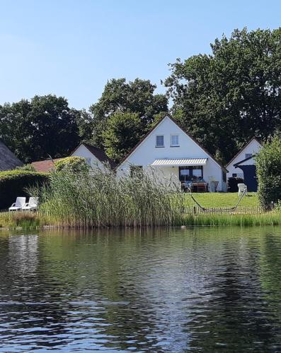 a house on the shore of a body of water at Luxe villa aan het meer in Heel