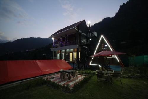 a house with a red cover and a table and an umbrella at Mahamaya camping Tosh in Tosh