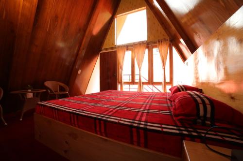 a large bed in a room with a window at Mahamaya camping Tosh in Tosh