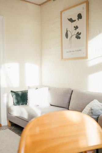 a living room with a couch and a table at Det gamle hus ved søen in Gråsten