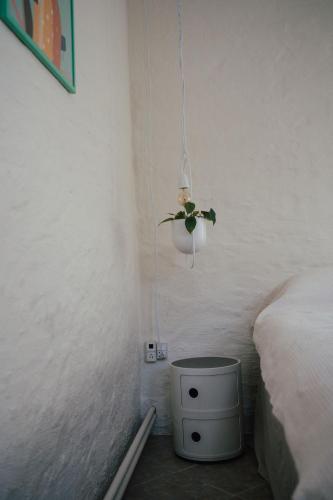 a room with a bed and a night stand with a plant at Det gamle hus ved søen in Gråsten