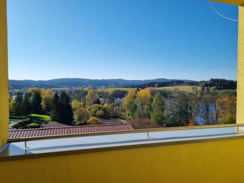 a window with a view of the fall foliage at Ubytování Hanka v pokoji s bakónem C408 in Frymburk