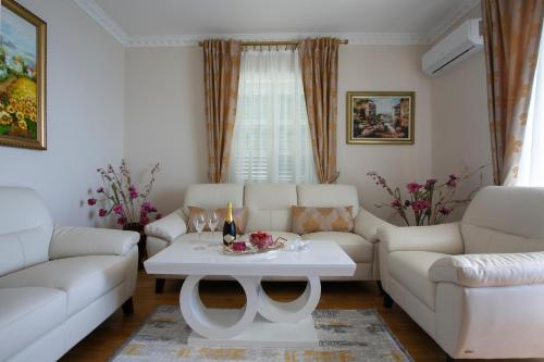 a living room with white couches and a table at Montesan Luxury Apartments Sveti Stefan in Sveti Stefan