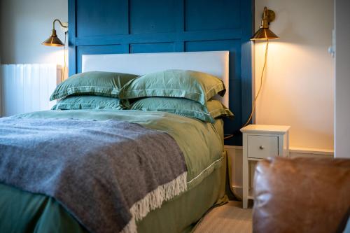 a blue bedroom with a bed with a blue headboard at The Nook in Debenham