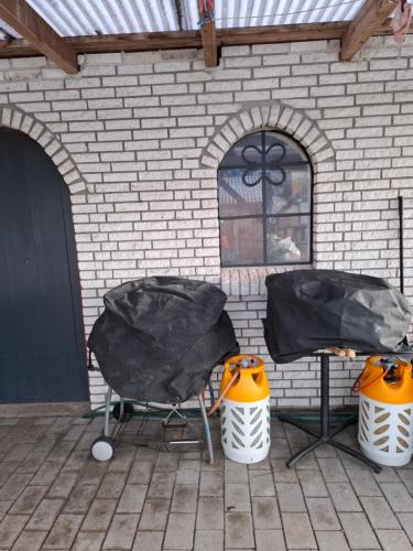 two chairs and a table in front of a brick building at oasen in Rødekro