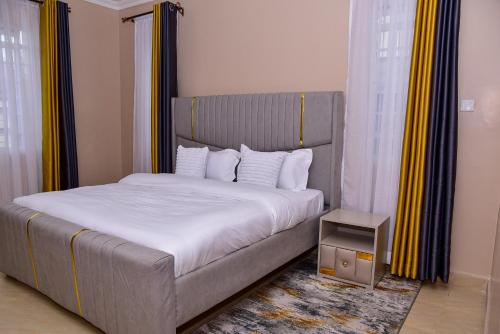 a bedroom with a large bed with white sheets at Barnabas Nakuru Comfy Homestays in Nakuru