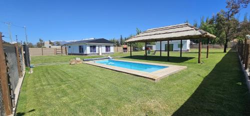a backyard with a swimming pool and a gazebo at Cabañas Willy Azul con pileta climatizada y parque en Mendoza in Las Compuertas