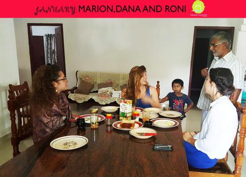 un grupo de personas sentadas alrededor de una mesa en Thekkady Homestay, en Thekkady