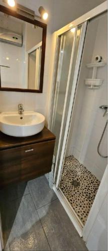 une salle de bain avec un lavabo et une douche avec un miroir dans l'établissement Studio 4 pers avec piscine, tennis et wifi, au Cap d'Agde