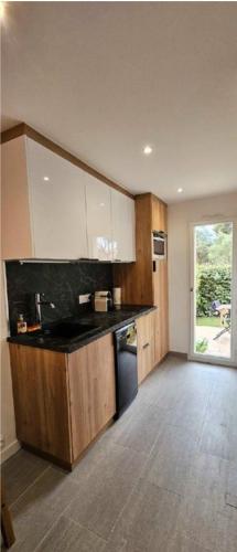 une cuisine avec des armoires en bois et un comptoir noir dans l'établissement Studio 4 pers avec piscine, tennis et wifi, au Cap d'Agde