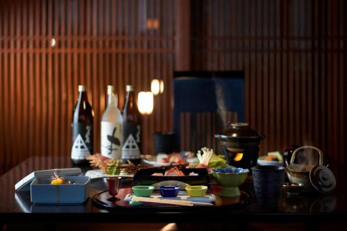 a table with a plate of food and bottles on it at Koran no Yu Kinkouro in Ibusuki