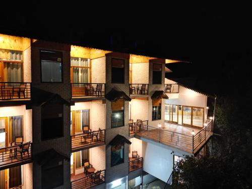 an apartment building with balconies at night at The Golden Castle Hotels in Mukteswar