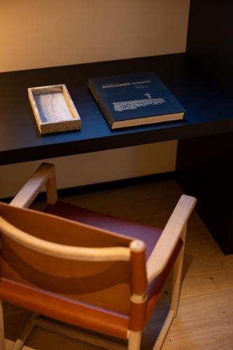 a chair sitting in front of a desk with a book at Les Suites by Cave Vauban in Dijon
