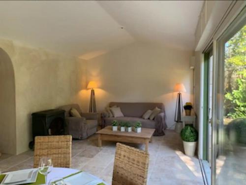 un salon avec un canapé et une table dans l'établissement Le Cottage Lascaux, à Bourrou