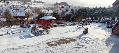 a snow covered yard with a bench and a gazebo at amel orawa in Podwilk