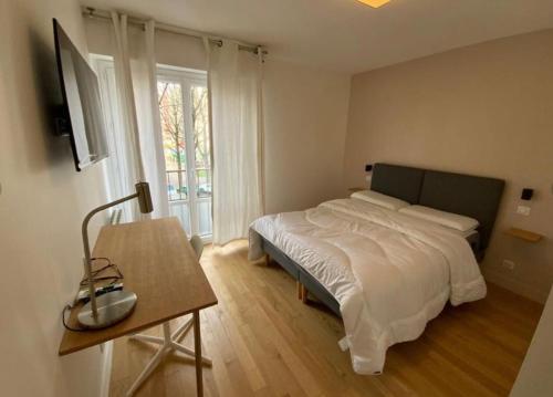 une chambre avec un lit et une table avec une lampe dans l'établissement 4 Bedroom Apartment - Near docks and metro, à Rouen