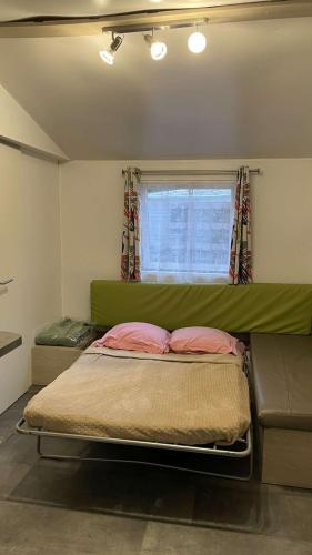 une chambre avec un grand lit avec une tête de lit verte dans l'établissement Le rivage des Landes, à Aureilhan