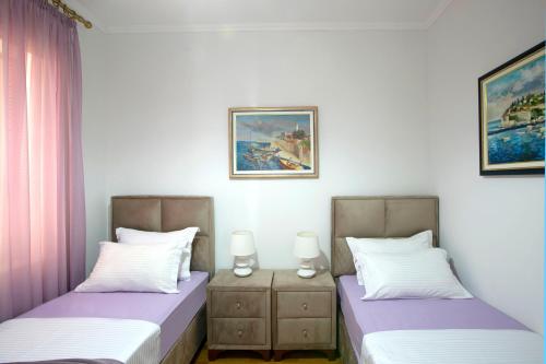 two beds sitting next to each other in a bedroom at Montesan Luxury Apartments Sveti Stefan in Sveti Stefan
