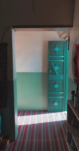 a bedroom with a blue dresser with fish on it at Tabrany in Qaryat Abū Bakr aş Şiddīq