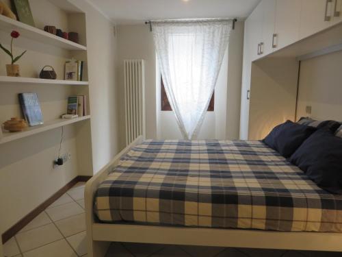a bedroom with a checkered bed with a window at Alloggio turistico Maison S Anselme VDA Aosta CIR 0015 in Aosta