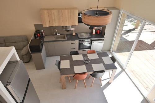 une cuisine avec une table et des chaises dans une pièce dans l'établissement Gîte le pontilh, à Saint-Privat