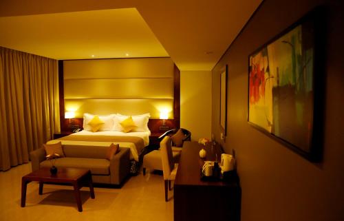 a hotel room with a bed and a couch at The Raviz Calicut in Kozhikode