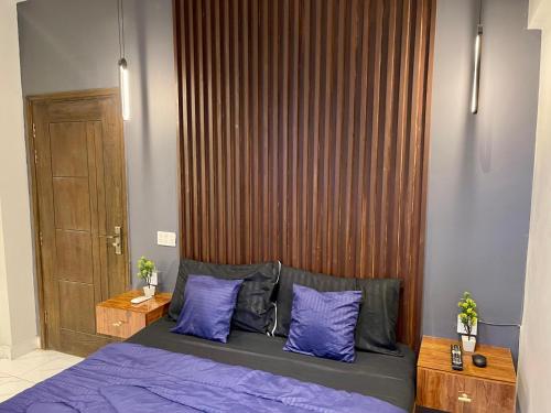 a bedroom with a bed with purple sheets and purple pillows at Beachfront Studios by Virani in Karachi