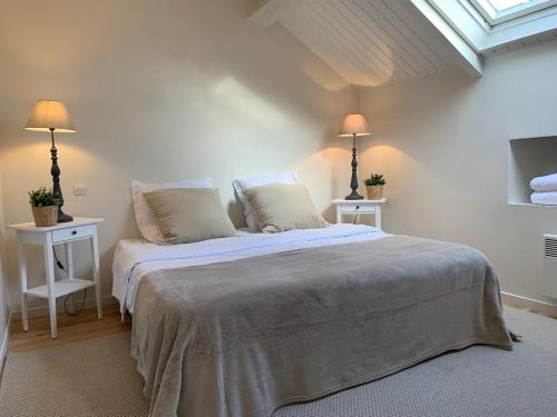 une chambre avec un lit avec deux tables et deux lampes dans l'établissement Le Cottage Monbazillac, à Bourrou