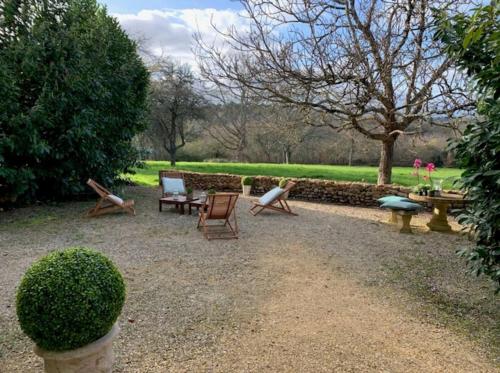 un groupe de chaises et de tables dans un jardin dans l'établissement Le Cottage Rouffignac, à Bourrou