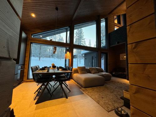 a living room with a table and a couch at Villa Outi, a Luxurious Villa in Äkäslompolo, Lapland in Äkäslompolo