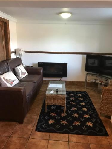a living room with a couch and a coffee table at Domvilles Farm self catering Courtyard Stable in Alsager
