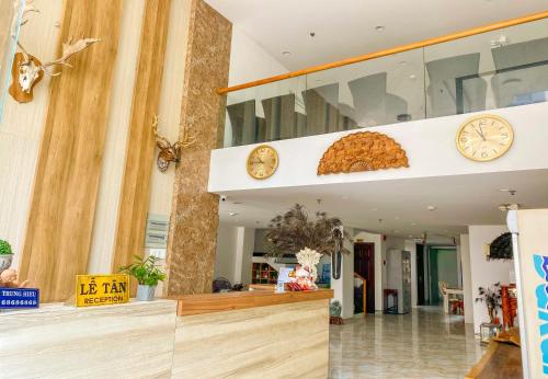 a lobby with clocks on the wall and a counter at Khách sạn Trung Hiếu Vũng Tàu in Vung Tau