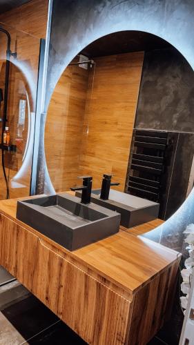 La salle de bains est pourvue d'un lavabo sur un comptoir en bois. dans l'établissement Appartement complètement rénové, à Scionzier