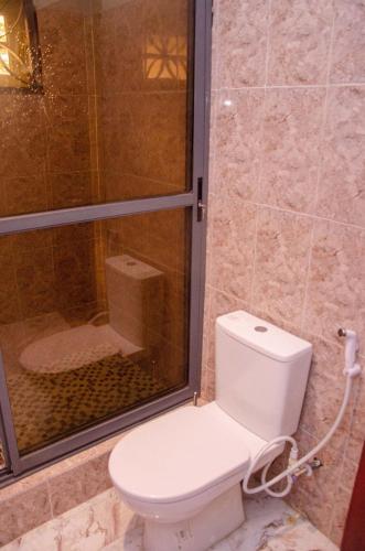 a bathroom with a toilet and a glass shower at Lovely 3 bedroom Villa in Ikorodu