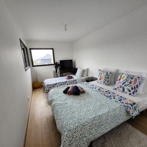 - une chambre avec 2 lits avec des oreillers et une fenêtre dans l'établissement Villa Maison 5 chambres, à Vitry-en-Artois