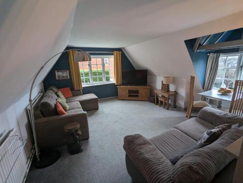 a living room with two couches and a table at Willow Cottage in Horning